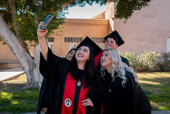 Graduates taking a selfie.
